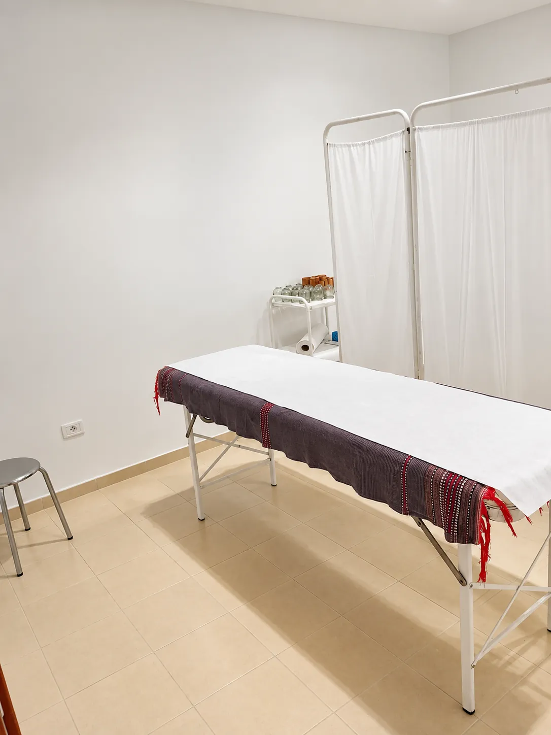 Salle de soins Relaxeo avec table de massage et paravent