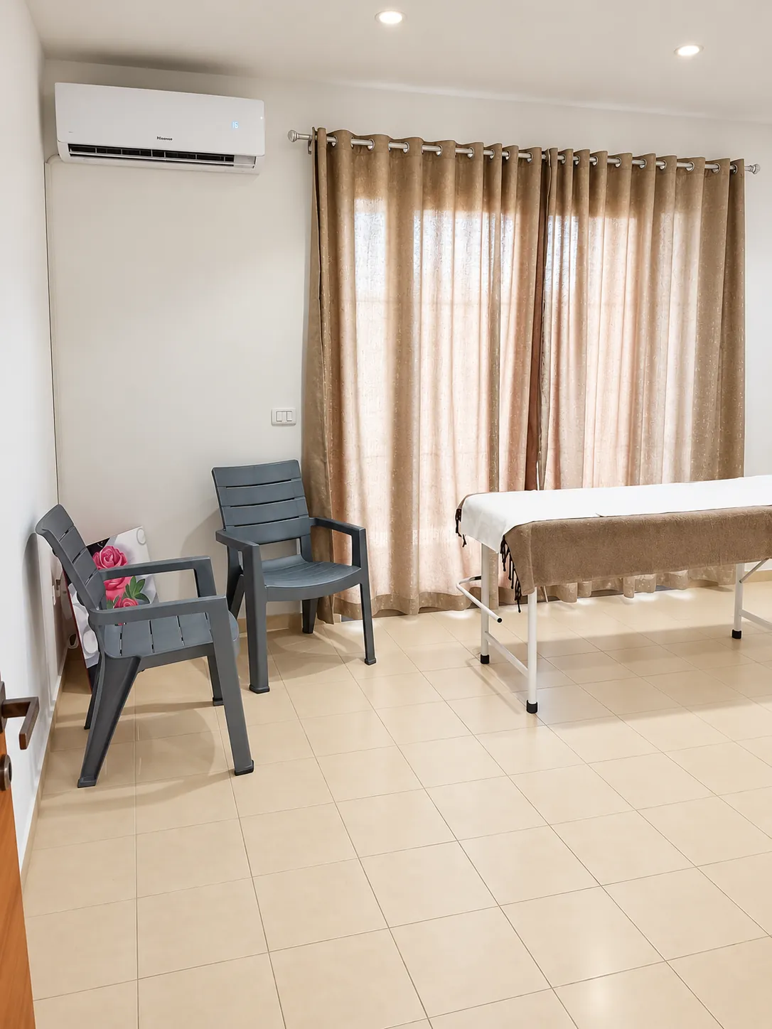 Salle de soins Relaxeo avec table de massage, fauteuils et grands rideaux